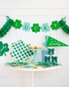 St. Patrick's Day-themed table setting with green decorations and 'Lucky' banner.