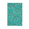 Floral patterned towel with pink flowers and green leaves on a teal background