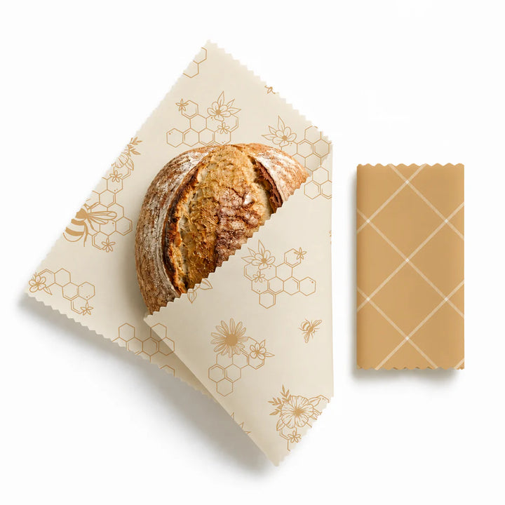 Wax wrap with bread and a block of beeswax on a white background