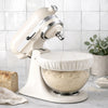 White KitchenAid stand mixer with dough in a bowl covered by a beeswax bowl cover on a kitchen counter. 