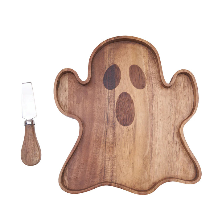 Wooden ghost-shaped serving board with a knife on a white background