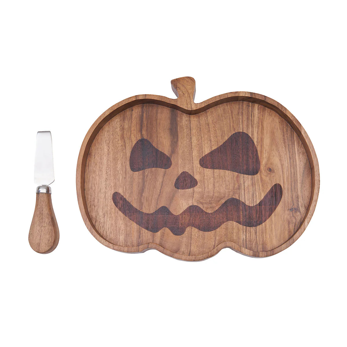 Wooden serving board shaped like a pumpkin with a carved face and a knife on a white background