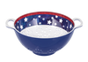 Blue colander with white stars on a red rim against a white background