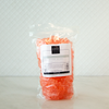 Packaged orange gummy bears with a label on a white background