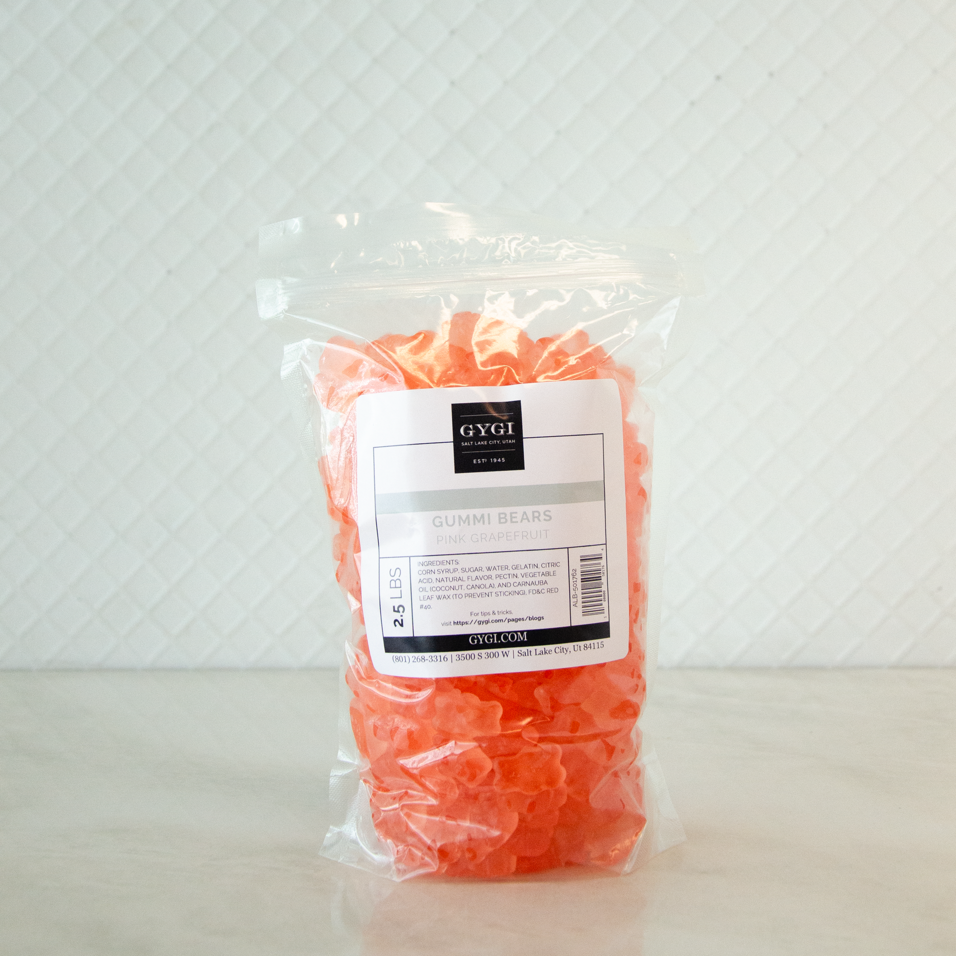 Packaged orange gummy bears with a label on a white background