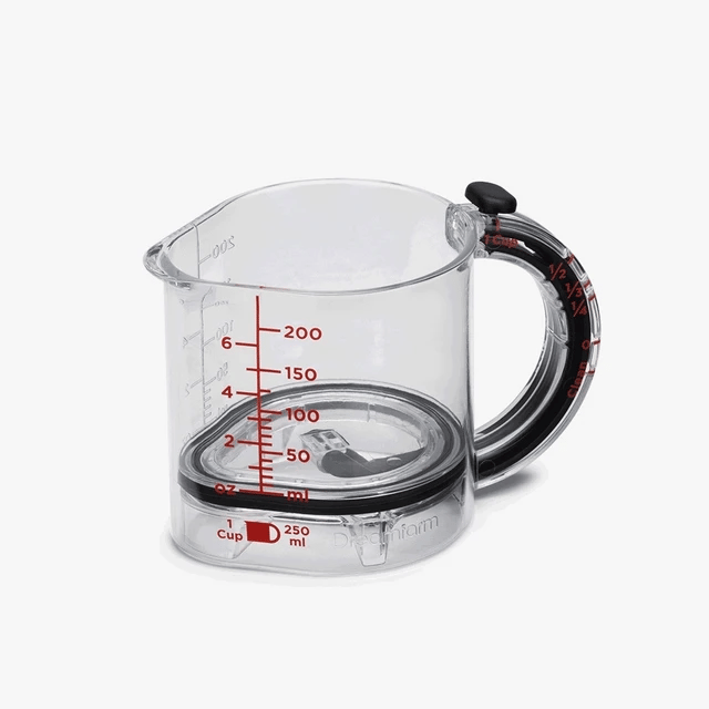 Clear measuring cup with black handle and red measurement markings on a white background