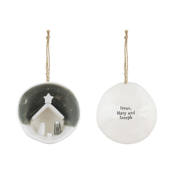 Decorative Christmas ornament with a nativity scene and text on a white background