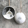 Decorative Christmas ornament with nativity design on one side and text on the other side a wooden surface