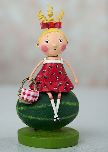 Decorative figurine of a girl in a watermelon dress sitting on a watermelon.