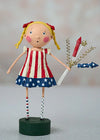 Patriotic figurine with American flag dress holding a bouquet of fireworks on a gray background
