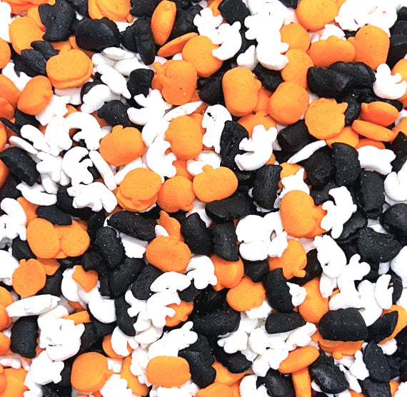 Halloween-themed sprinkles in orange, black, and white in the shape of ghosts, bats and pumpkins.