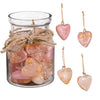 A glass jar of pink hanging resin hearts with four hanging hearts to the right on a white background.