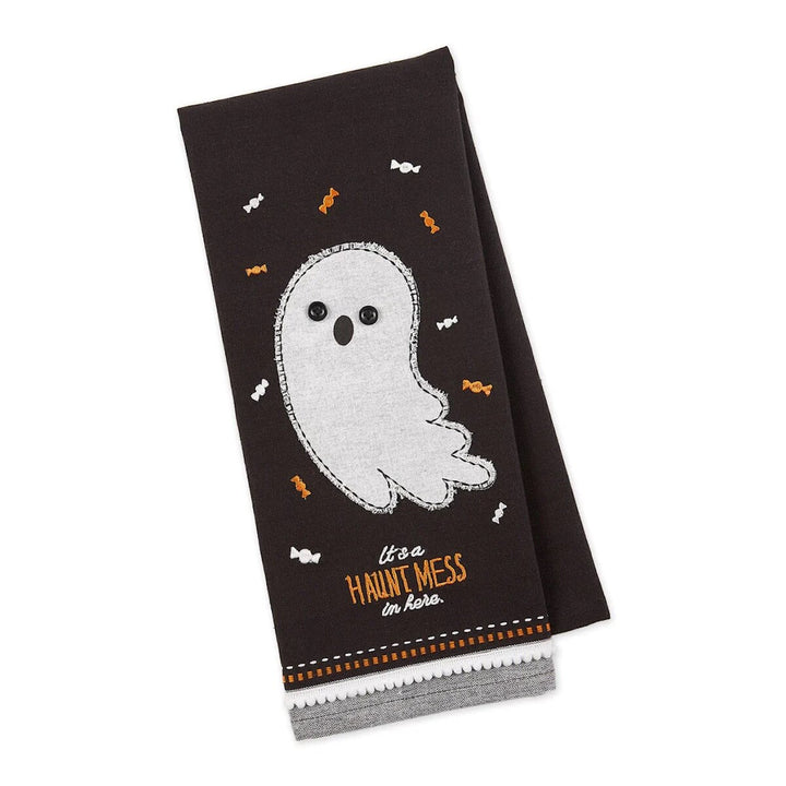 A black kitchen towel with a white embroidered ghost and the text 'It's a Haunt Mess In Here' along with small orange and black Halloween-themed embellishments.