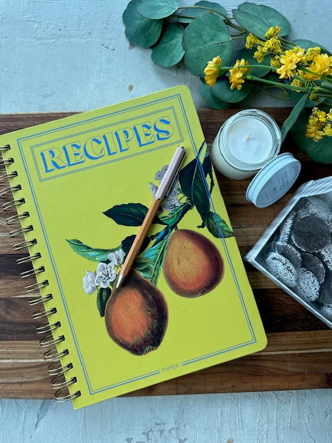Cookbook titled 'RECIPES' with a decorative cover featuring fruits and leaves on a wooden surface.