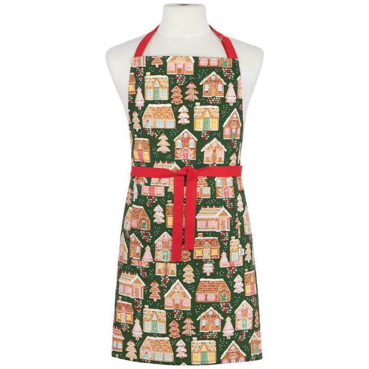 Christmas-themed apron with gingerbread house pattern on a mannequin against a white background.