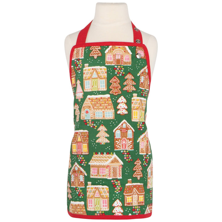 Christmas-themed apron with gingerbread house design on a mannequin against a white background.