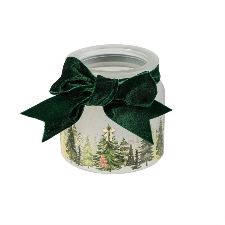 Decorative glass jar with green velvet bow and forest design on a white background