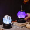 Two Halloween-themed lanterns, one with a skeleton hand and the other with a witch's hat, on a dark background.