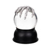 White lantern snow globe with a black base featuring a skeleton hand emerging from it on a white background