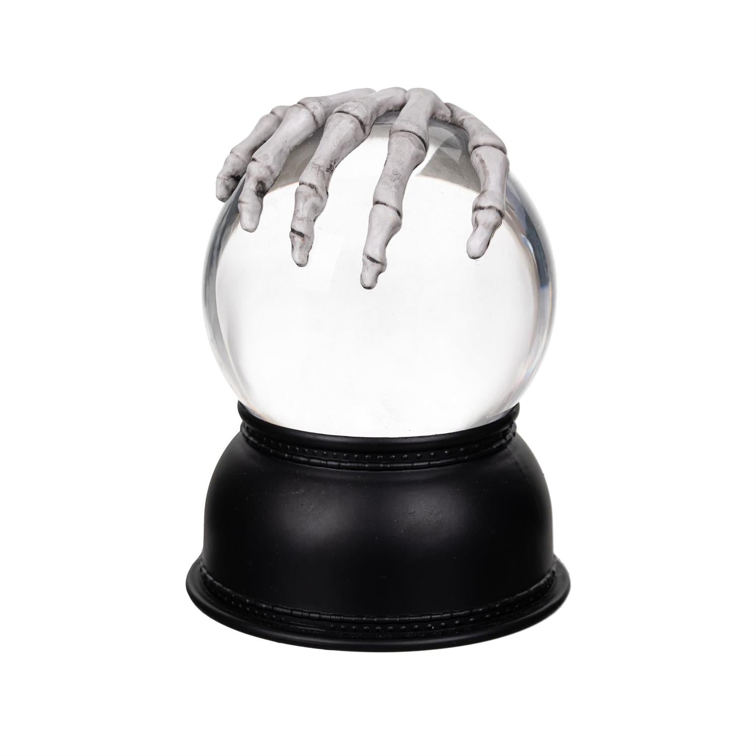 White lantern snow globe with a black base featuring a skeleton hand emerging from it on a white background