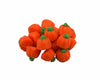 Orange pumpkin-shaped candy with green stems on a white background