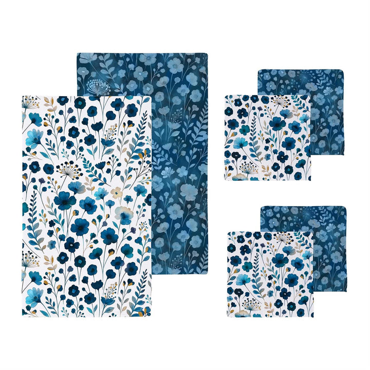 Set of blue floral patterned towels and wash cloths on a white background