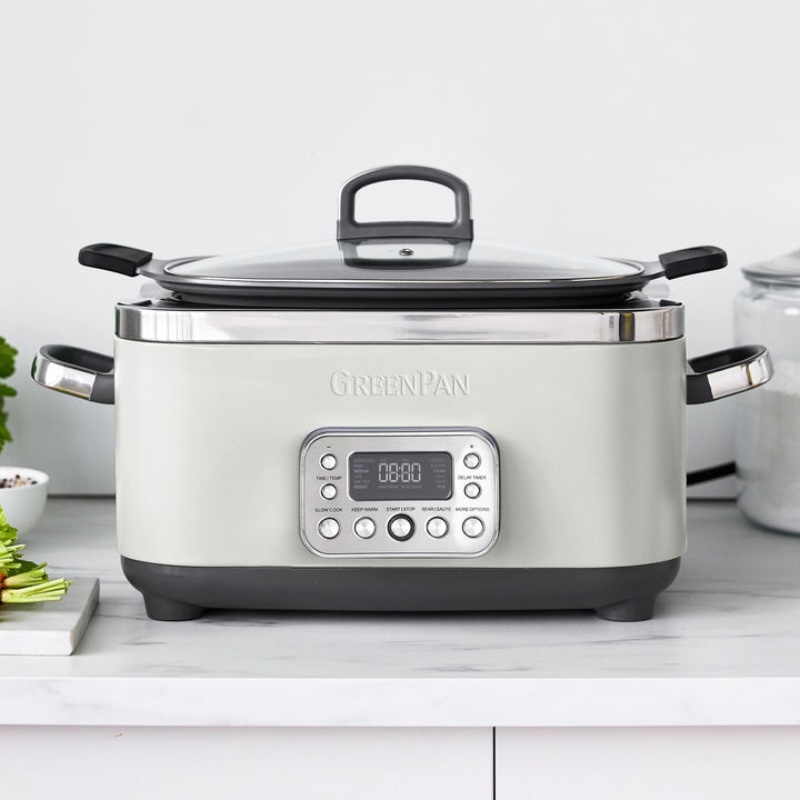 White multi-cooker with digital display on a kitchen counter, featuring the GreenPan brand.