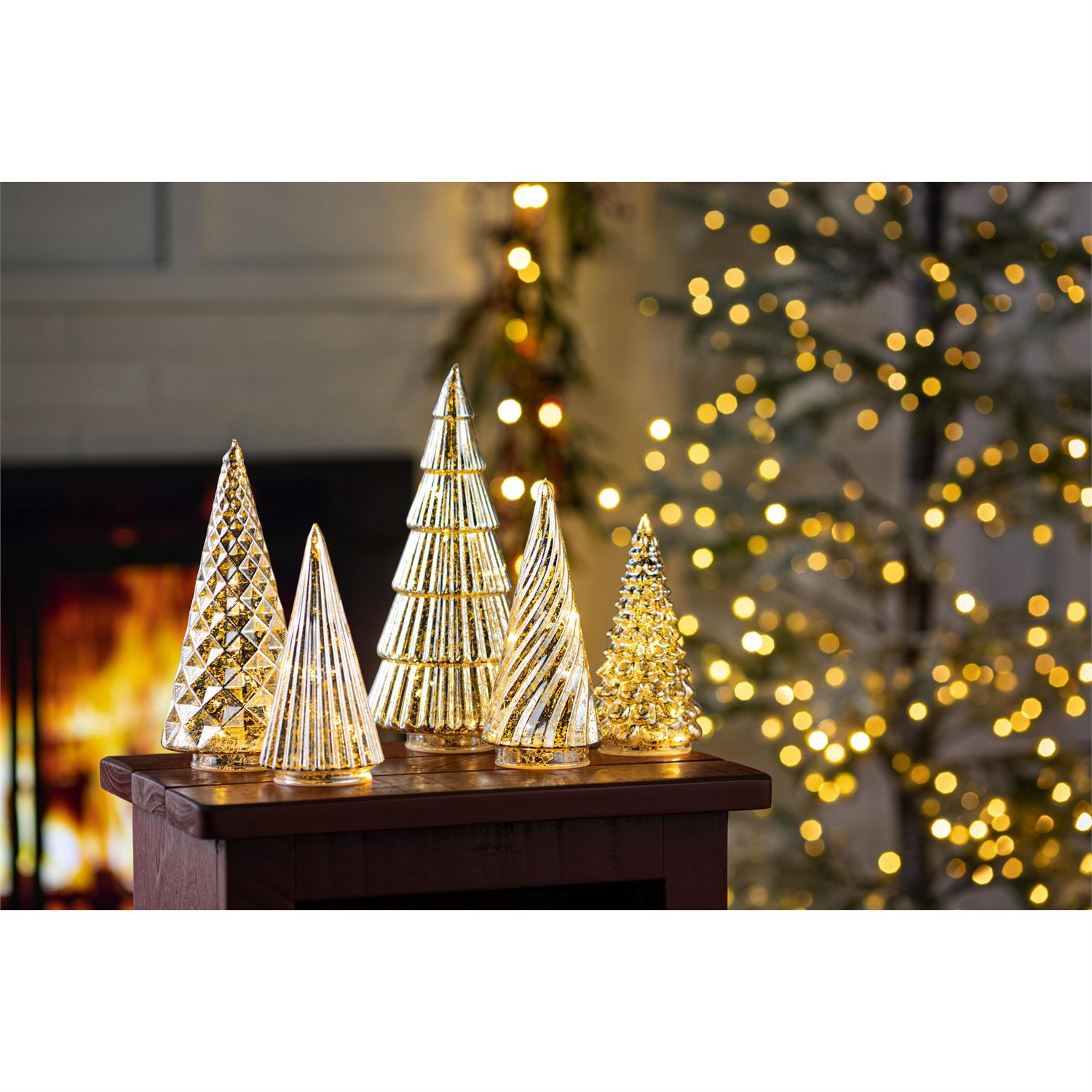 Decorative Christmas trees on a table with a blurred festive background
