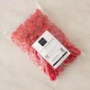 5 pound bag of red cinnamon devil candy on a beige background.