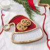 Santa hat-shaped serving plate with cookies on a festive tablecloth.