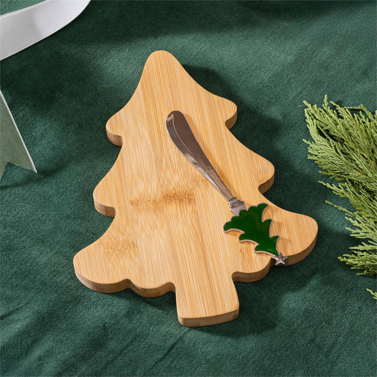 Bamboo tree-shaped cutting board with a knife on a green surface