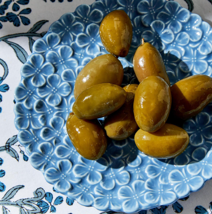 Olives on a blue decorative plate with floral patterns