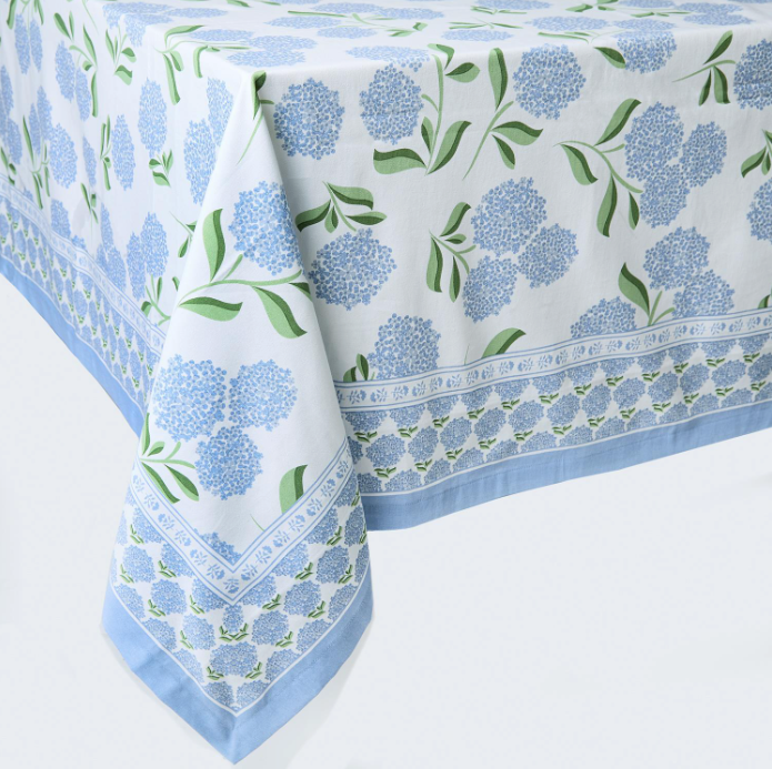 Tablecloth with blue flowers and green leaves on a white background