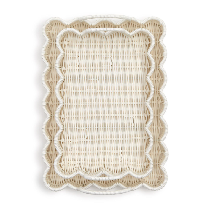 Wicker basket trays stacked together with scalloped edges on a white background