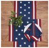 American flag-themed table runner, placemat and napkins on a wooden surface with a plant.