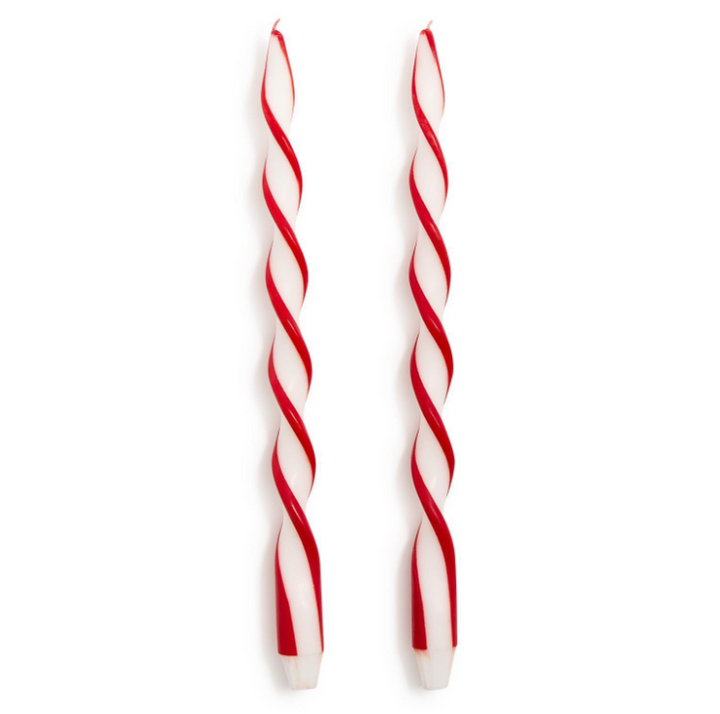 Two red and white striped candles on a white background
