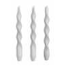 Three white twisted candles on a white background