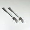 Two silver forks on a white background