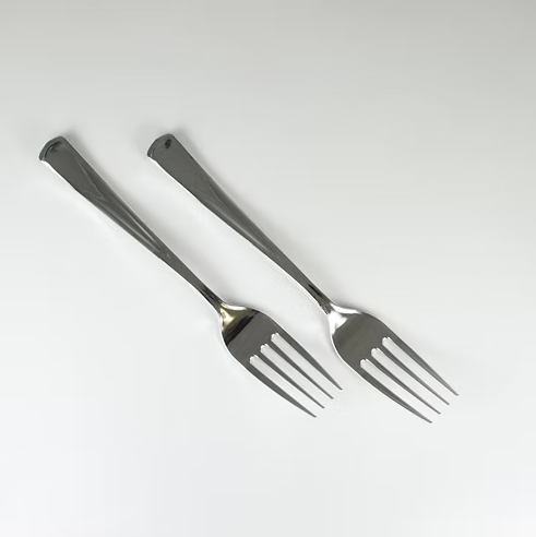 Two silver forks on a white background