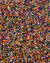 A close-up of small round sprinkles in four classic colors: orange, purple, white, and green.