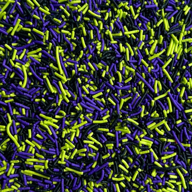 A close-up, view of sprinkles in three colors: bright purple, neon lime green, and black.