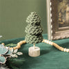 Green fabric tree on a wooden base with a green background