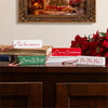 Decorative Christmas signs on a wooden surface with a festive background.