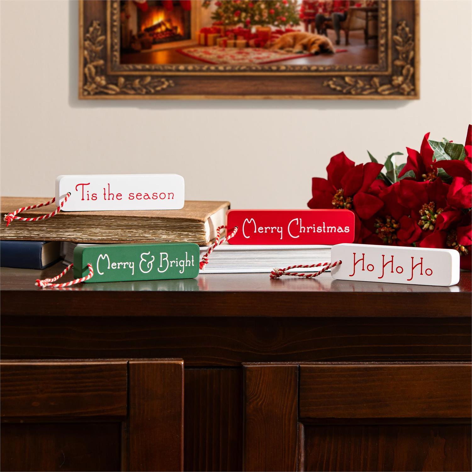 Decorative Christmas signs on a wooden surface with a festive background.