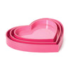 Set of three pink heart-shaped trays on a white background