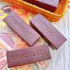 Three chocolate squishy bars with 'CHOCOLATE' text on a textured surface