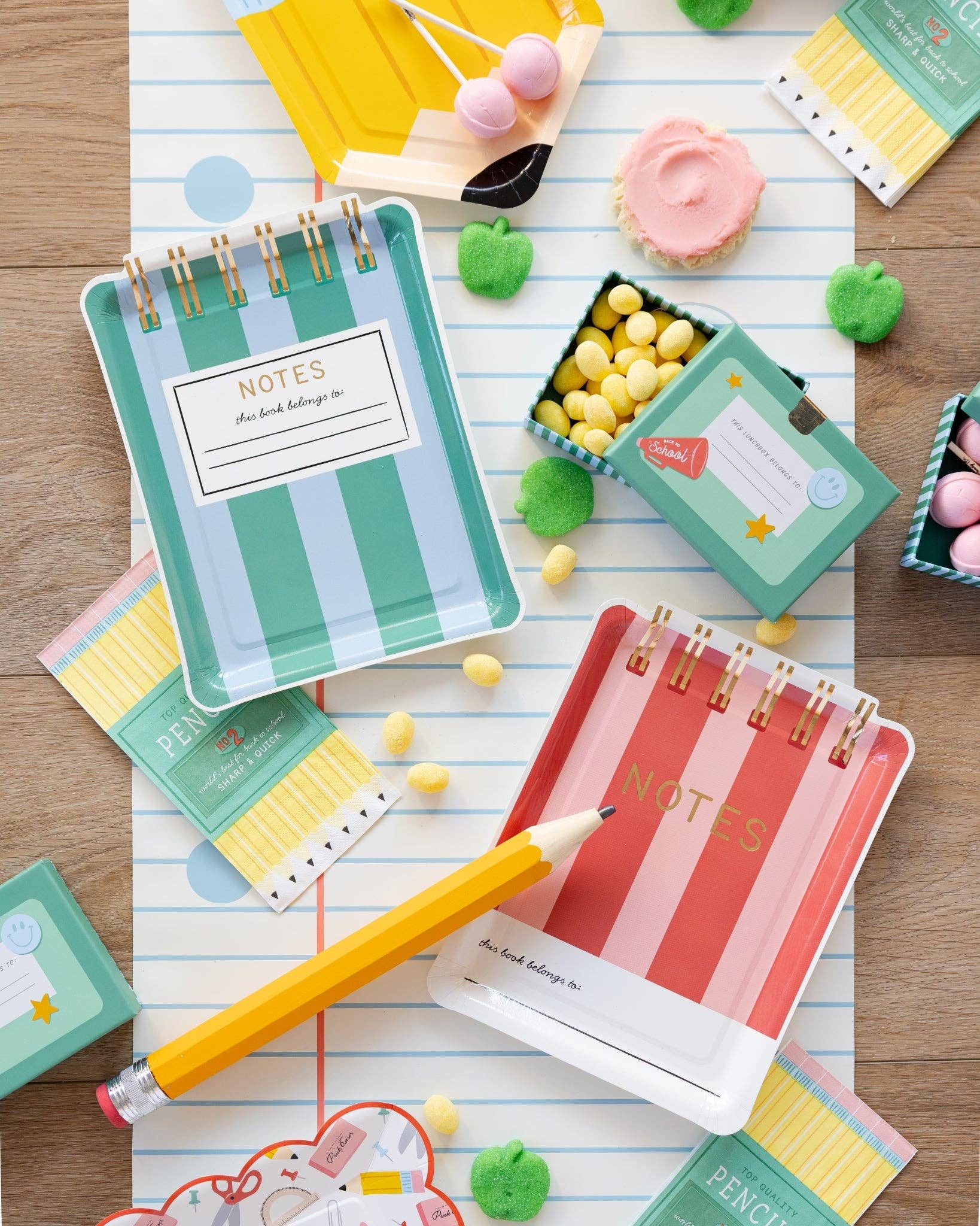 Colorful notebook plates with striped designs on a wooden surface with small decorative items.
