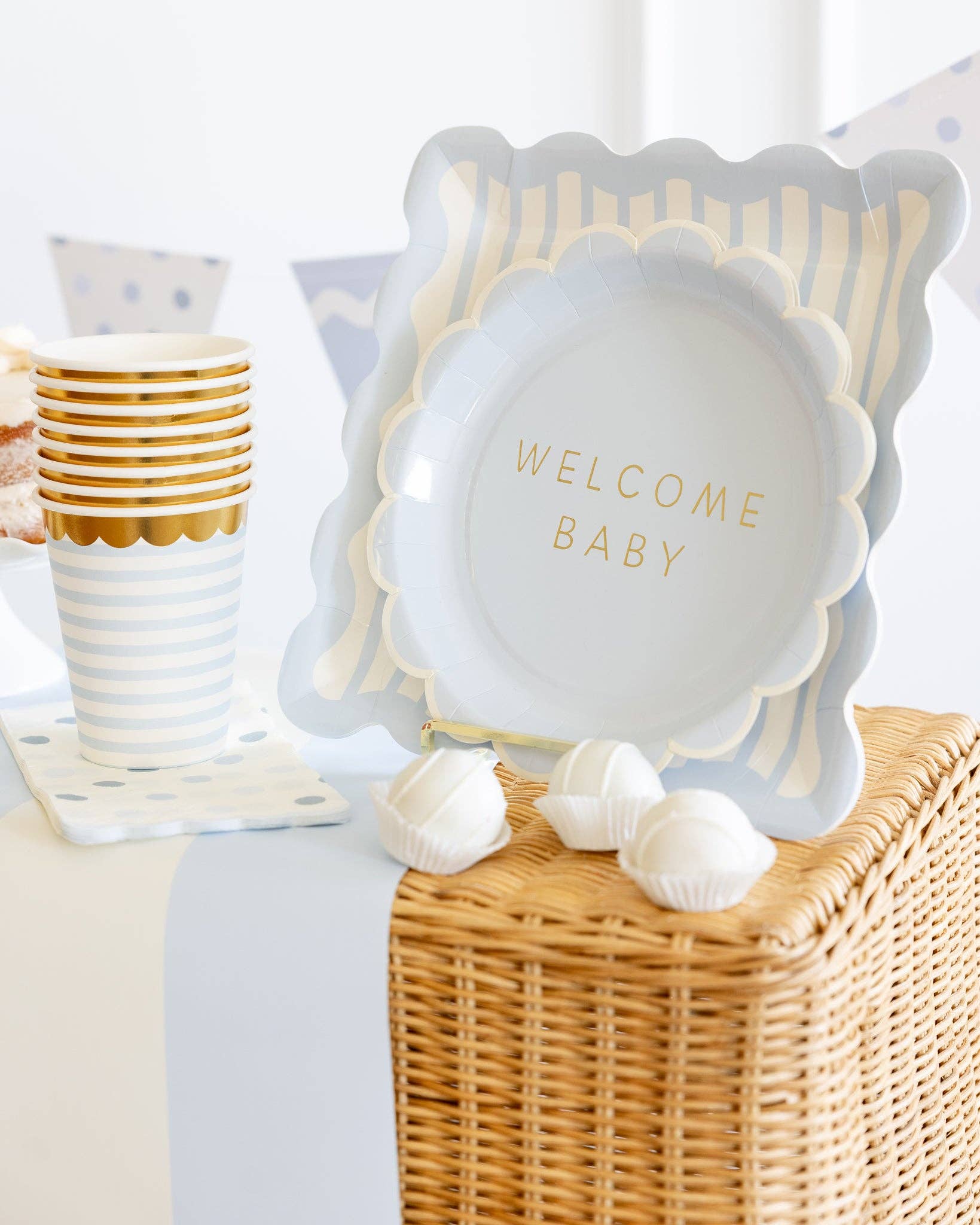 Decorative plate with 'Welcome Baby' text on a wicker box with decorations.