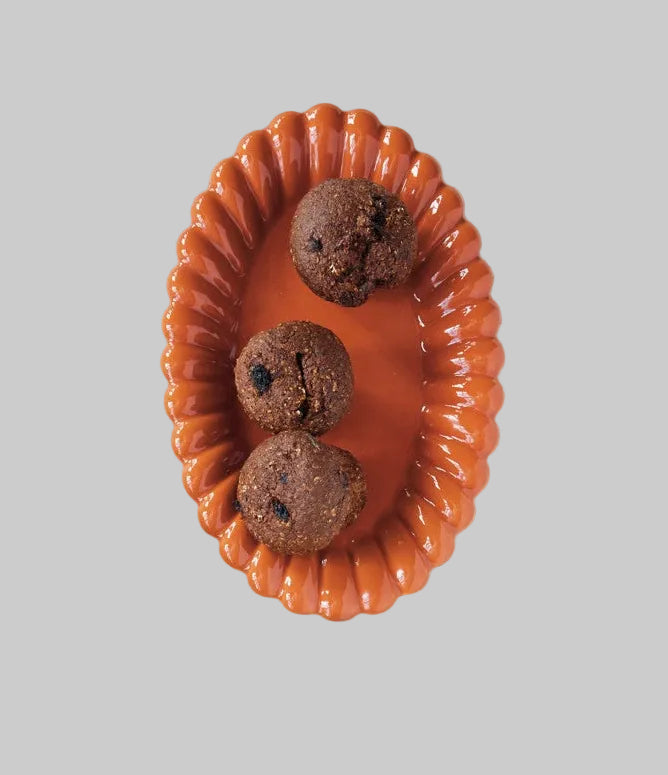 An orange decorative platter with pastries on it, on a white background.