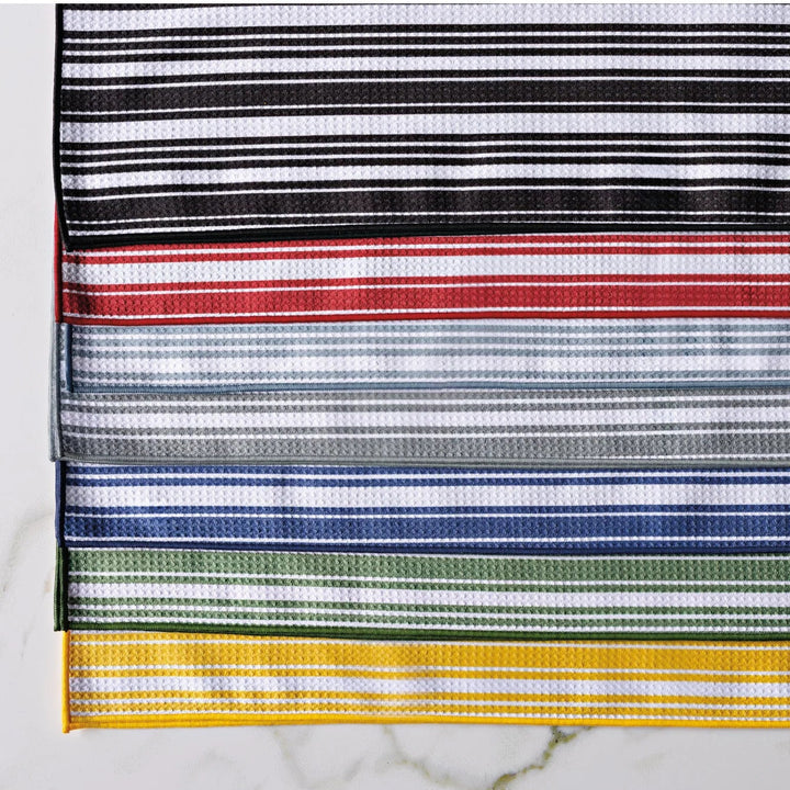 Striped kitchen towels available in black, red, blue, green, and yellow on a white marble background